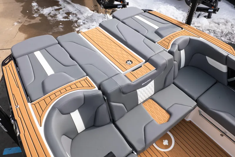 Slide: The Image of 2026 MasterCraft XT24 boat interior with gray and tan seating, snow in background. - 30