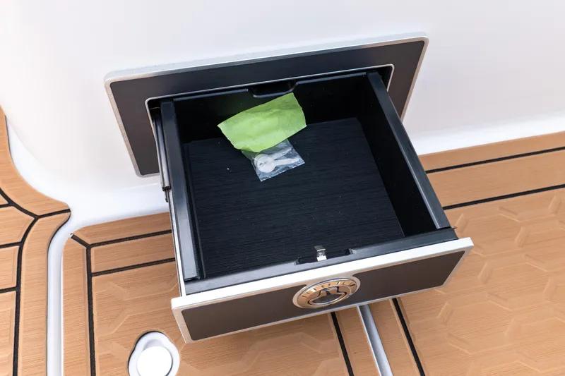Slide: The Image of Open storage drawer on 2026 MasterCraft XT24 boat with teak flooring. - 41