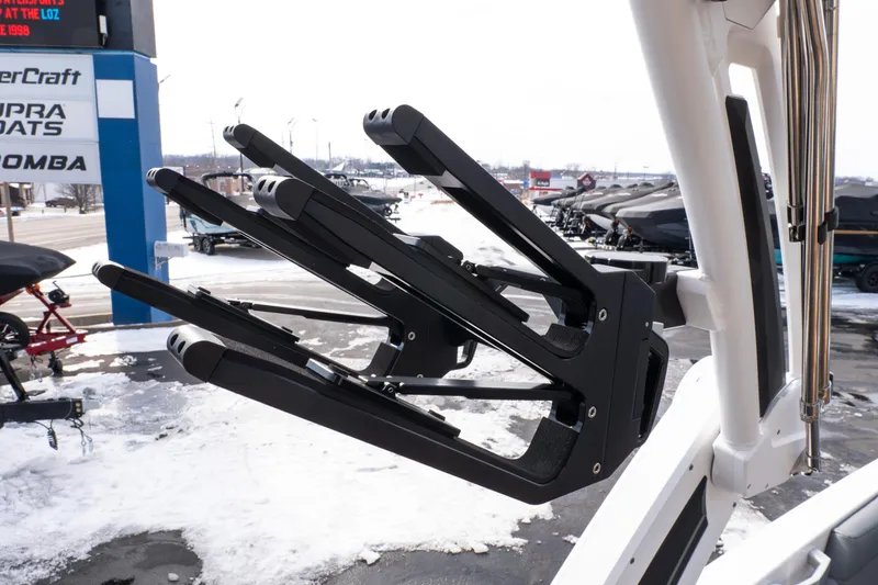 Slide: The Image of 2026 MasterCraft XT24 boat with a sleek black wakeboard rack in a snowy dealership setting. - 44