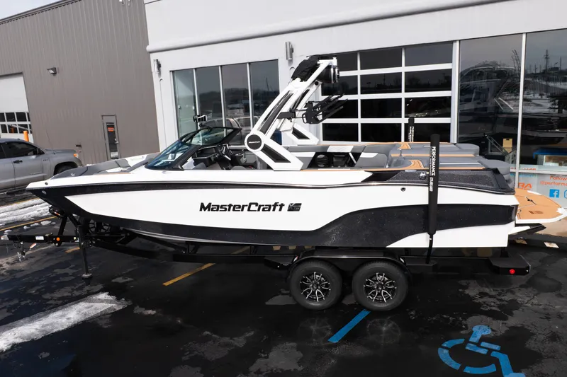 Slide: The Image of 2026 MasterCraft XT24 boat on trailer outside dealership. - 48
