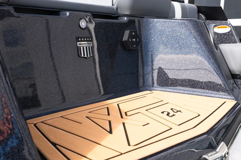 Slide: The Image of 2026 MasterCraft XT24 boat interior with logo and wooden deck detail. - 52