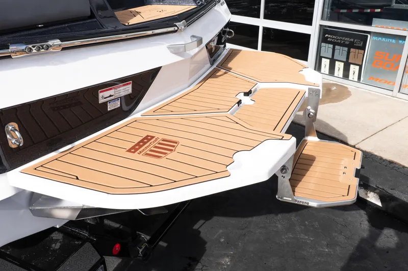 Slide: The Image of 2026 MasterCraft XT24 boat swim platform with teak-style decking, displayed outdoors. - 53