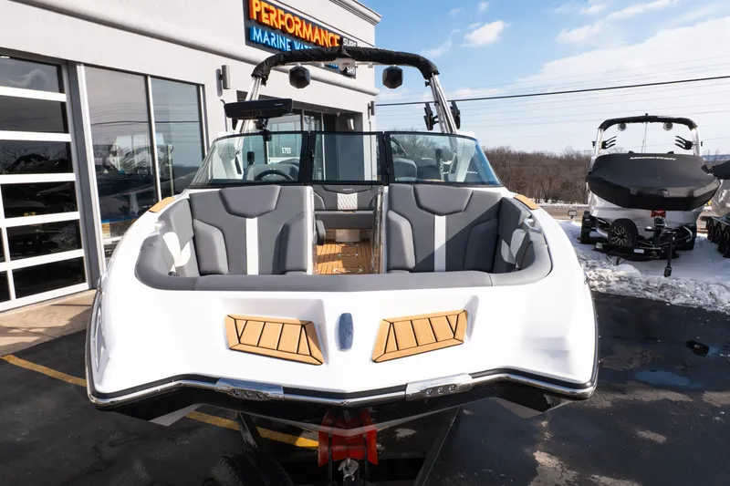 Slide: The Image of 2026 MasterCraft XT24 boat displayed at a marine dealership, showcasing sleek design and seating. - 58