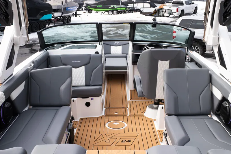 Slide: The Image of 2026 MasterCraft XT24 boat interior with gray seating and wood flooring. - 7
