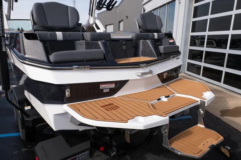 Slide: The Image of 2026 MasterCraft XT24 boat with teak swim platform and cushioned seating. - 77