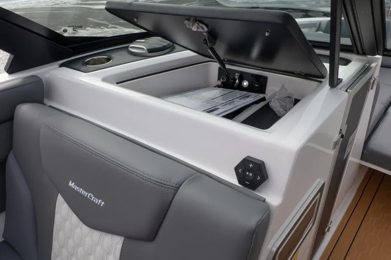 Slide: The Image of 2026 MasterCraft XT24 boat interior with open storage compartment and control panel. - 9