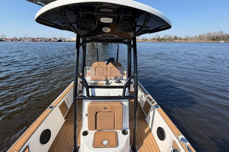 Slide: The Image of 2022 Sea Pro 228 Bay boat on calm water, featuring sleek design and spacious deck. - 11