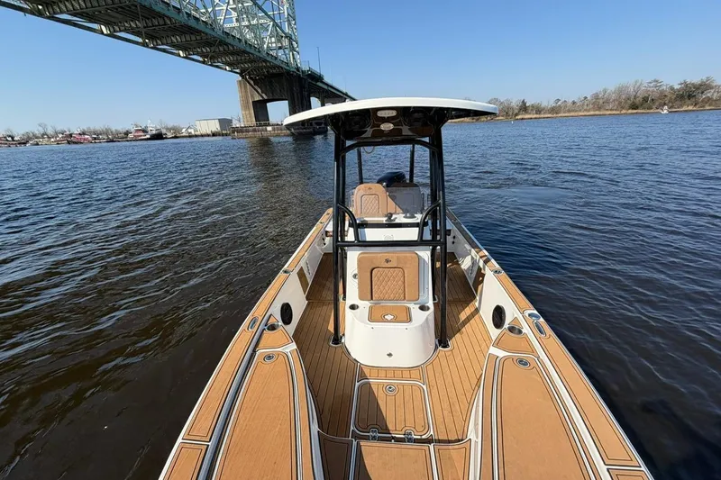 Slide: The Image of 2022 Sea Pro 228 Bay boat on water near a bridge, showcasing deck and console. - 12