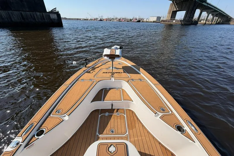 Slide: The Image of 2022 Sea Pro 228 Bay boat on water near a bridge, showcasing deck design. - 13