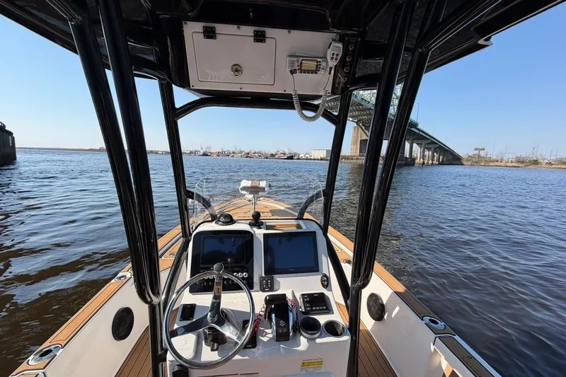 Slide: The Image of 2022 Sea Pro 228 Bay boat interior with dual screens, steering wheel, and bridge view. - 8