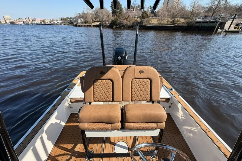 Slide: The Image of 2022 Sea Pro 228 Bay boat interior with tan seats on a calm river. - 9