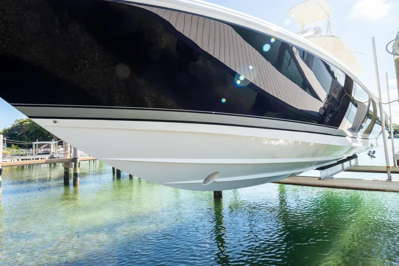 Slide: The Image of 2015 Intrepid 400 Center Console boat on lift over clear water. - 118