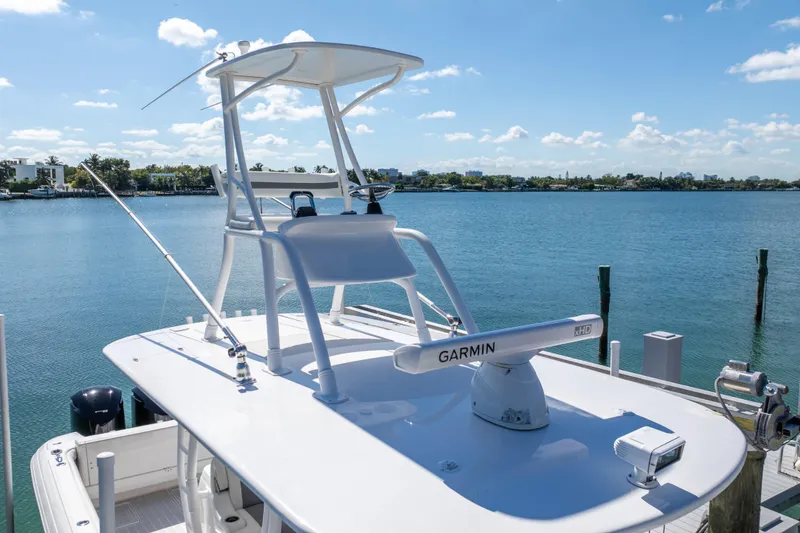 Slide: The Image of 2015 Intrepid 400 Center Console boat with Garmin radar, docked by a scenic waterfront. - 12