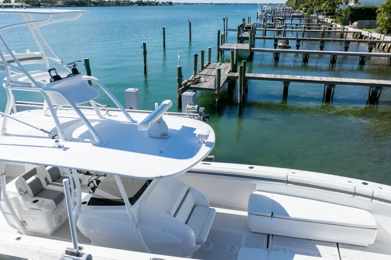 Slide: The Image of 2015 Intrepid 400 Center Console boat docked by a serene waterfront. - 17