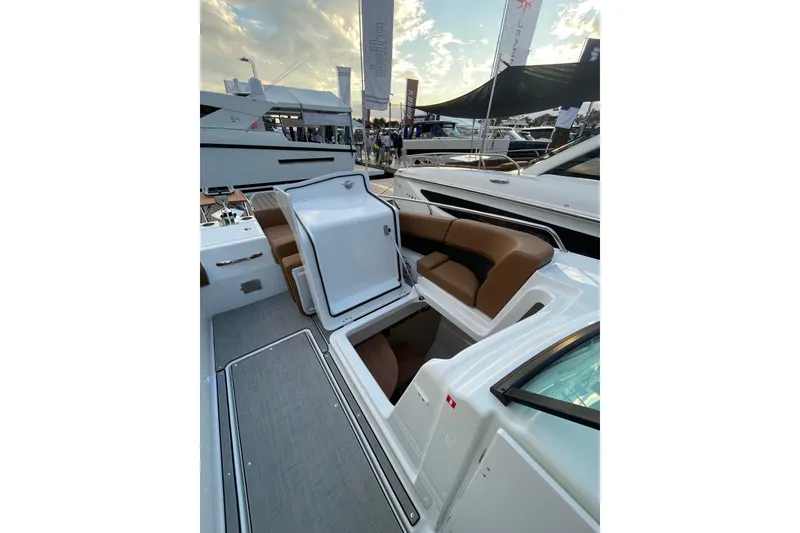 Slide: The Image of 2026 Jeanneau TH33 boat interior with brown seating and open storage compartment. - 19