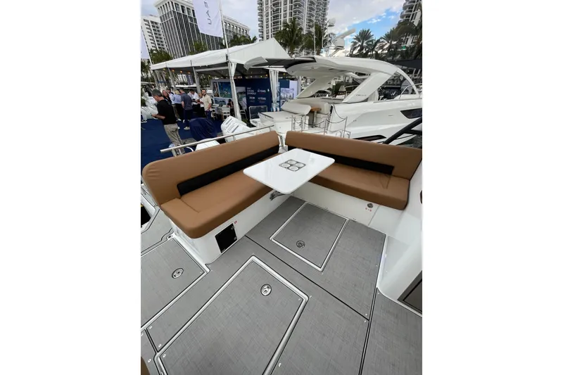 Slide: The Image of 2026 Jeanneau TH33 yacht with elegant seating and table at a boat show. - 26