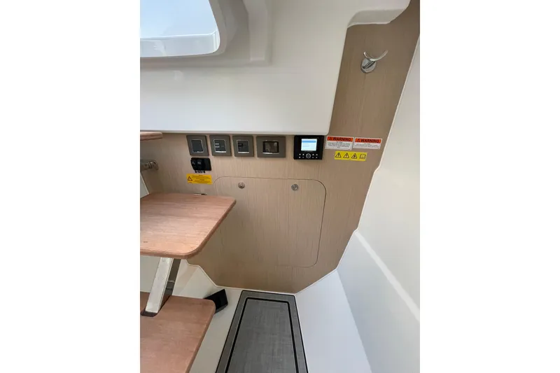 Slide: The Image of 2026 Jeanneau TH33 interior control panel with wooden steps and safety warnings. - 27