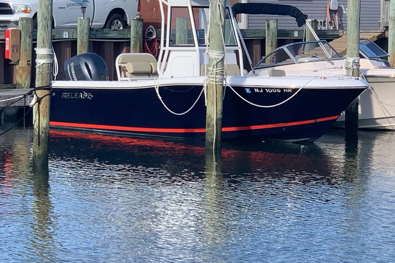 Slide: The Image of 2021 Release 210 RX boat docked in marina, featuring sleek design and powerful engine. - 2