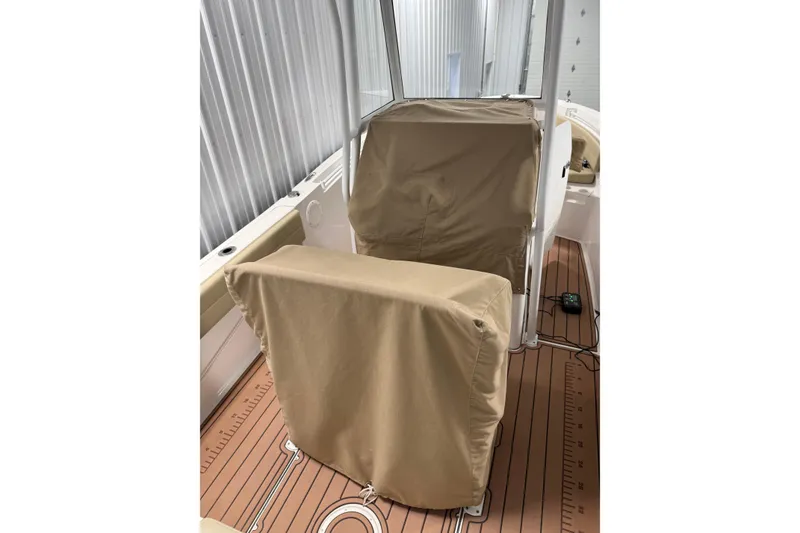 Slide: The Image of 2021 Release 210 RX boat interior with covered seats and wooden deck. - 5