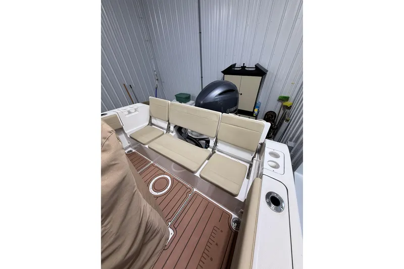 Slide: The Image of 2021 Release 210 RX boat interior with beige seating and Yamaha engine in storage. - 6