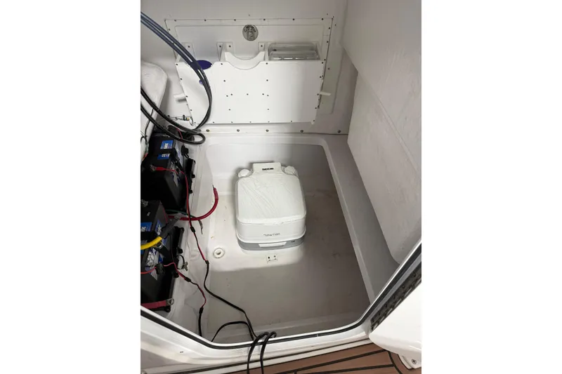 Slide: The Image of Interior of 2021 Release 210 RX boat featuring a portable toilet and battery compartment. - 8