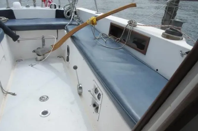 Slide: The Image of 1974 Pearson 30 sailboat cockpit with blue seating and wooden tiller. - 10