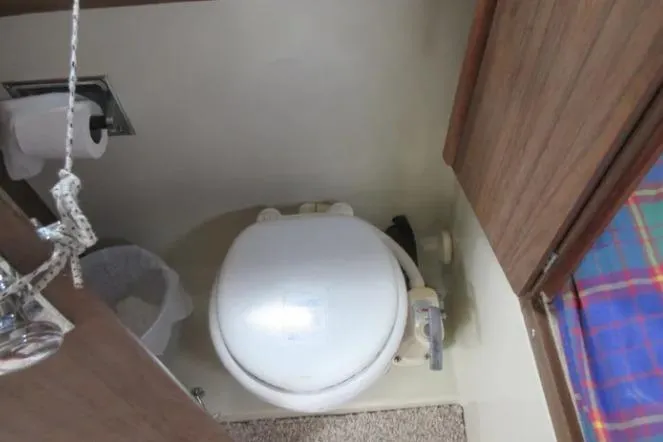 Slide: The Image of 1974 Pearson 30 sailboat bathroom with compact toilet and wooden cabinetry. - 17