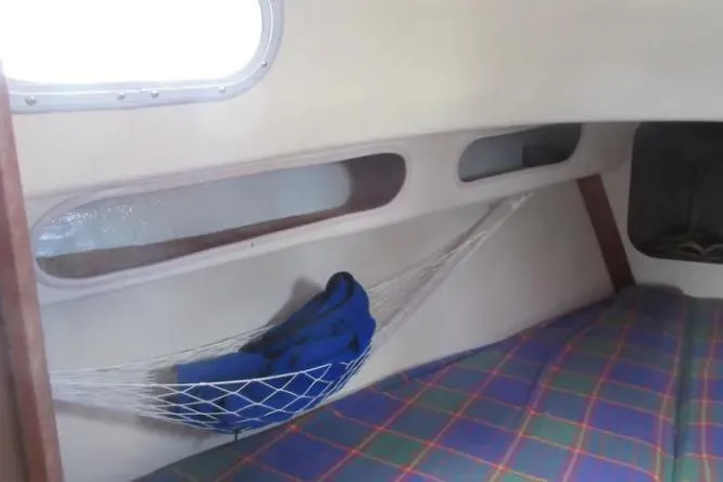 Slide: The Image of Interior of a 1974 Pearson 30 sailboat with plaid cushions and a net hammock. - 18