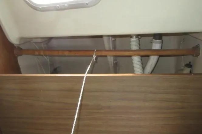 Slide: The Image of Interior view of a 1974 Pearson 30 sailboat showing wooden and rope details. - 19