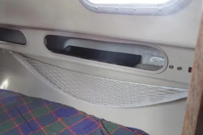 Slide: The Image of Interior of a 1974 Pearson 30 sailboat with storage netting and plaid bedding. - 20