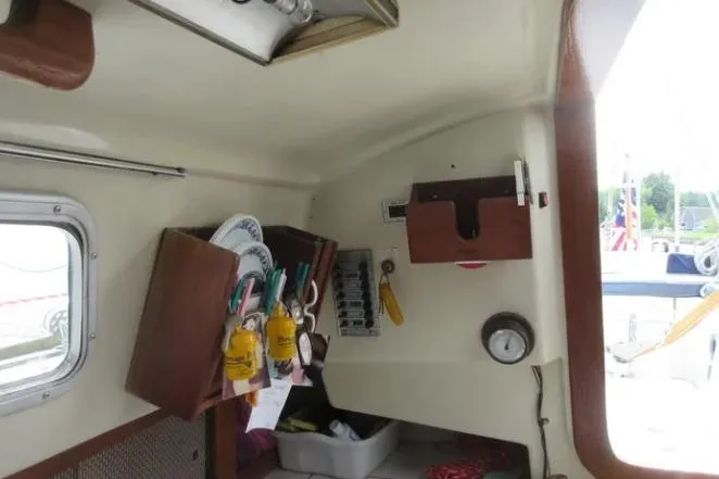 Slide: The Image of Interior of a 1974 Pearson 30 sailboat with wooden storage and nautical equipment. - 21