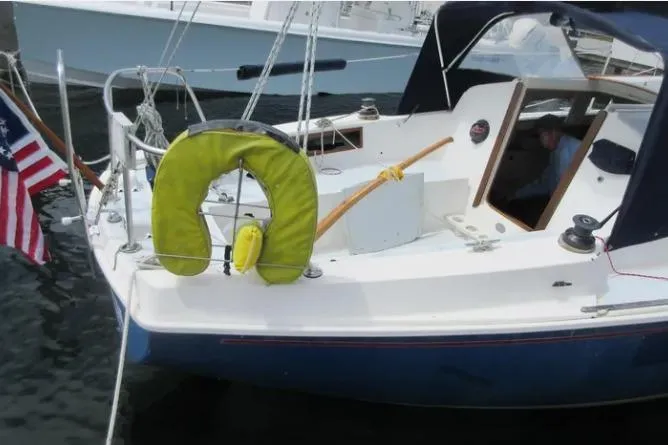 Slide: The Image of 1974 Pearson 30 sailboat with American flag and life preserver, docked in marina. - 4