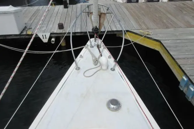 Slide: The Image of 1974 Pearson 30 sailboat bow at dock, featuring deck fittings and mooring lines. - 5