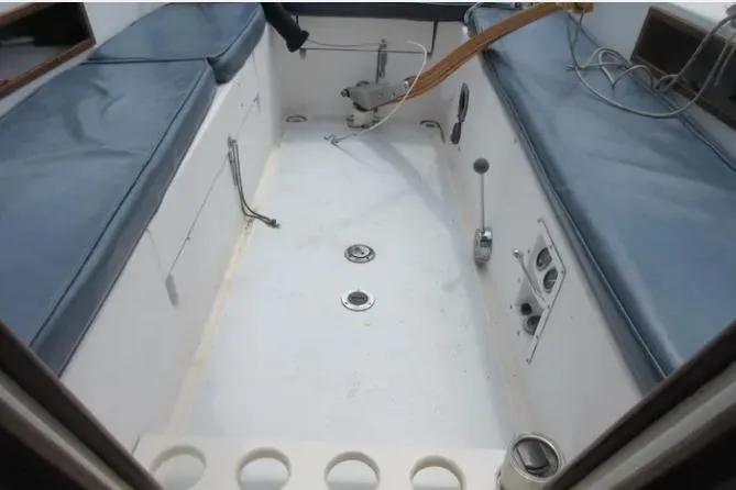 Slide: The Image of 1974 Pearson 30 sailboat cockpit with blue cushions and steering controls. - 8