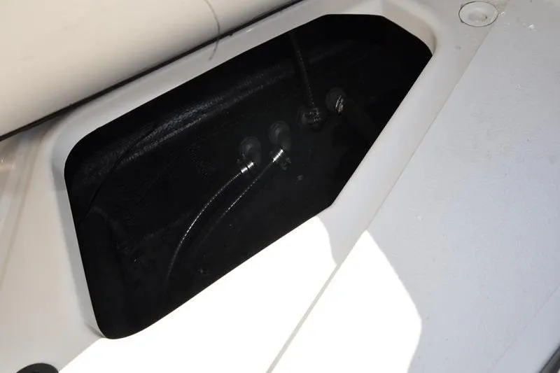 Slide: The Image of Storage compartment in a 2021 Stingray 201 DS boat, featuring internal wiring. - 13
