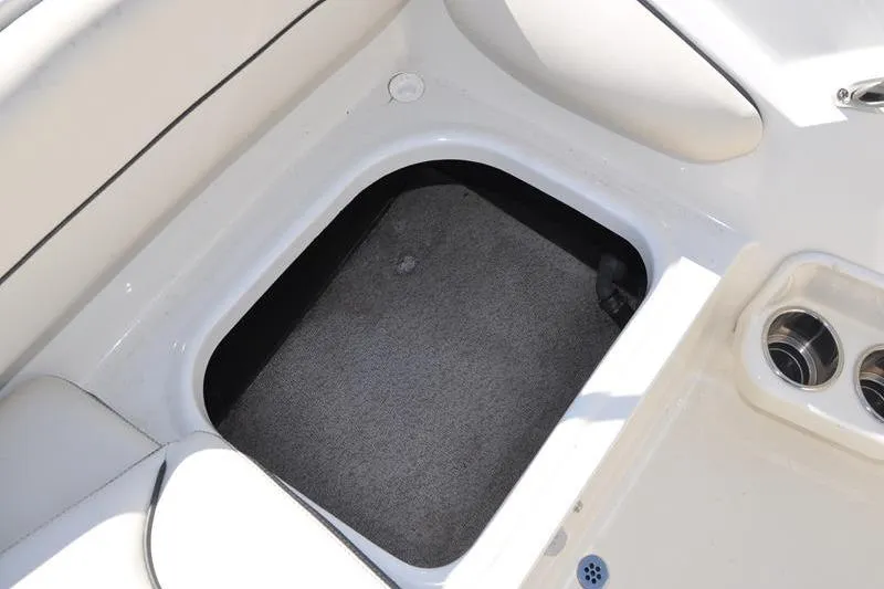 Slide: The Image of Storage compartment in 2021 Stingray 201 DS boat, featuring cup holders and cushioned seating. - 14