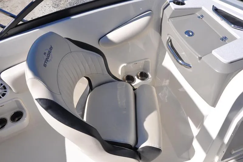 Slide: The Image of 2021 Stingray 201 DS boat interior with cushioned seat and storage compartment. - 15