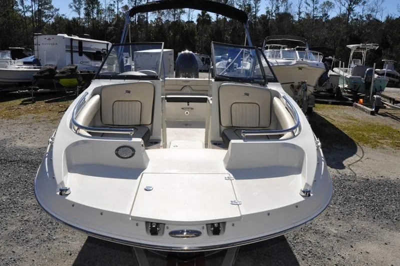 Slide: The Image of 2021 Stingray 201 DS boat with open deck, parked outdoors in a marina. - 8