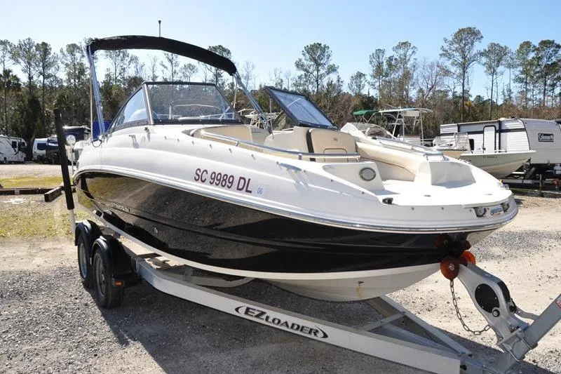 Slide: The Image of 2021 Stingray 201 DS boat on trailer, parked outdoors with trees in background. - 9
