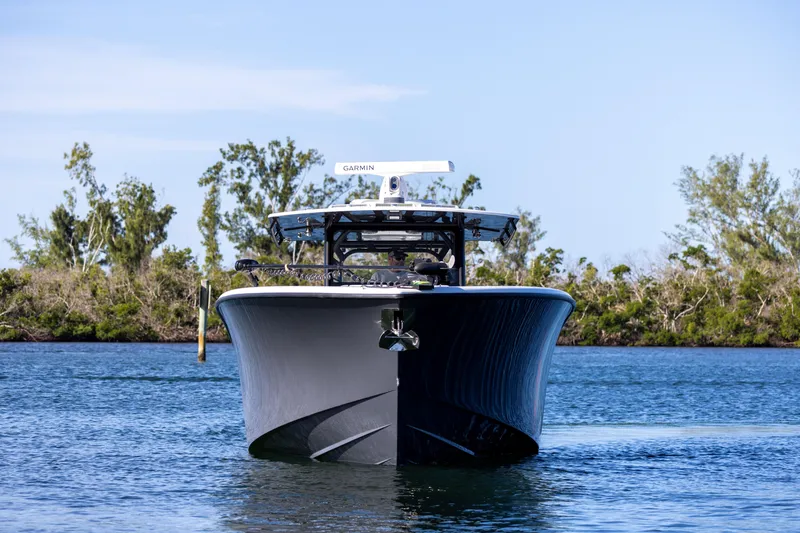Slide: The Image of 2023 Yellowfin 42 boat on calm water with trees in the background. - 11