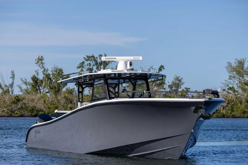Slide: The Image of 2023 Yellowfin 42 boat on calm water with trees in the background. - 12
