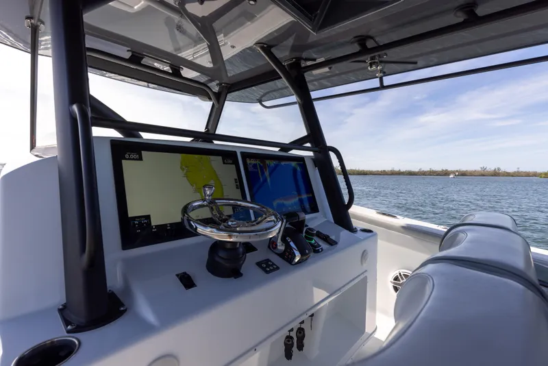 Slide: The Image of 2023 Yellowfin 42 boat helm with navigation screens and steering wheel. - 43