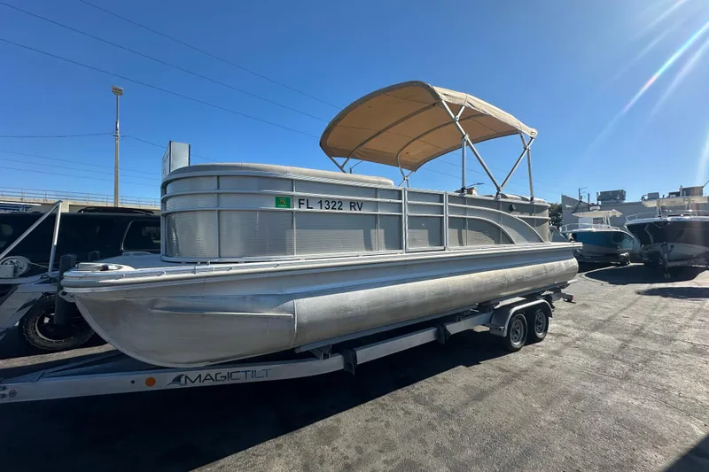 Slide: The Image of 2018 Bennington 24 SSRX pontoon boat on trailer under clear blue sky. - 1