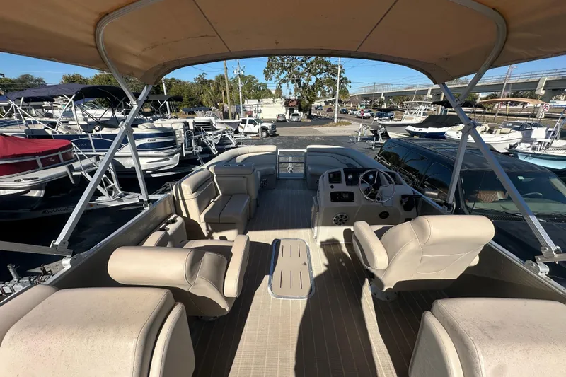 Slide: The Image of 2018 Bennington 24 SSRX pontoon boat with beige seating and canopy in a marina setting. - 10