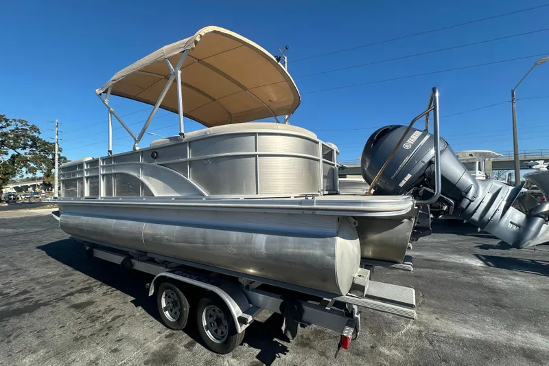 Slide: The Image of 2018 Bennington 24 SSRX pontoon boat with canopy and Yamaha outboard motor on trailer. - 2