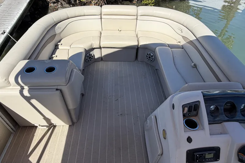 Slide: The Image of 2018 Bennington 24 SSRX pontoon boat interior with beige seating and cup holders. - 4