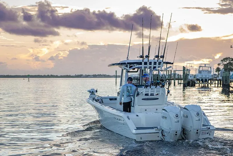 Slide: The Image of Manufacturer Provided Image: 2026 Cobia 245 Center Console boat on water at sunset with fishing rods. - 5
