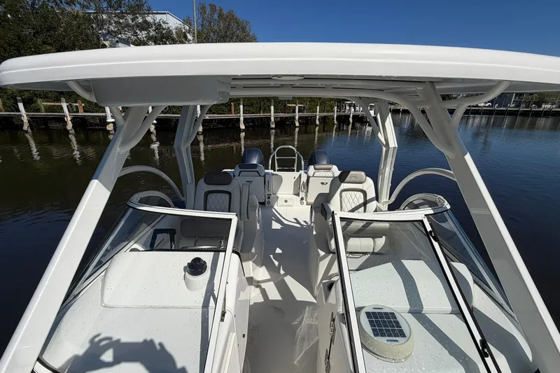 Slide: The Image of 2023 World Cat 255 DC boat interior with seating and console, docked on calm water. - 14