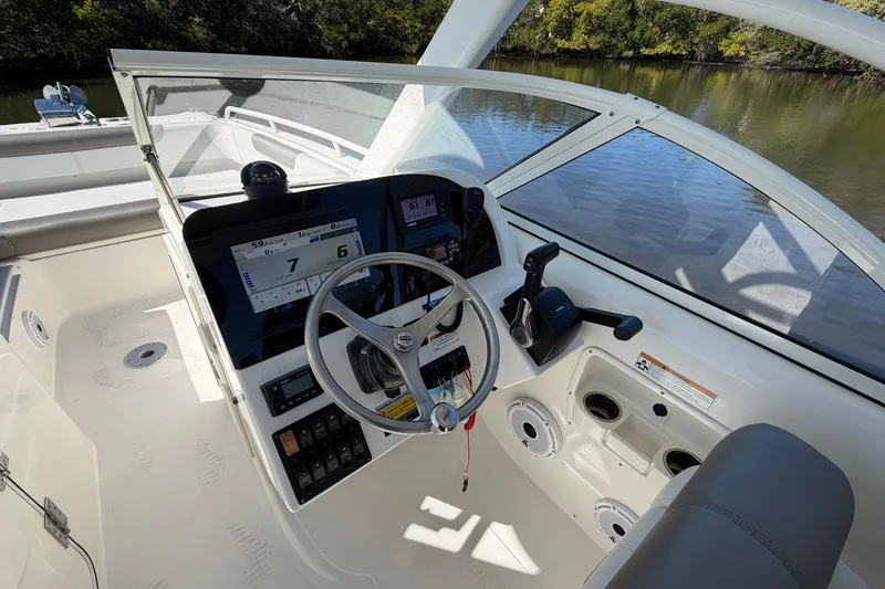 Slide: The Image of 2023 World Cat 255 DC boat helm with steering wheel, controls, and navigation display. - 16