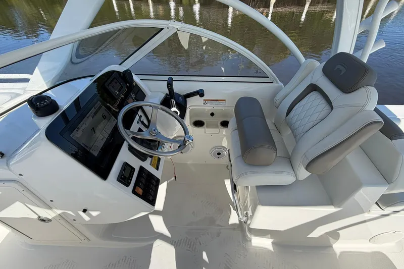 Slide: The Image of 2023 World Cat 255 DC boat cockpit with modern steering and comfortable seating. - 18